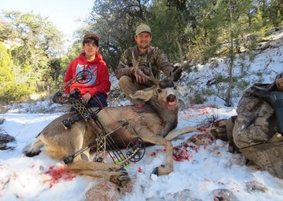 A hunter posing with a deer that they shot and killed